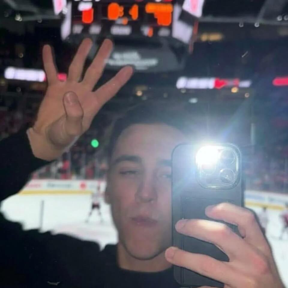 Blurry selfie fist-pump, half-asleep fan lit by phone glow